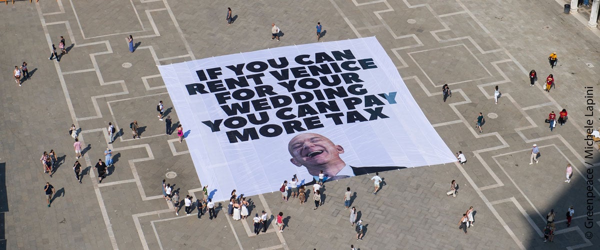 Banner auf dem Marktplatz in Venidig „If you can rent Venice for your wedding, you can pay more tax.“